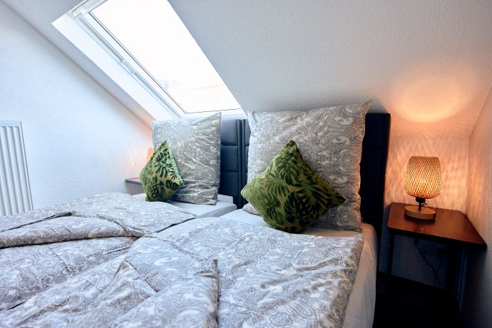 Schlafzimmer mit großem Fenster und Blick in den Himmel des Apartments Happy life