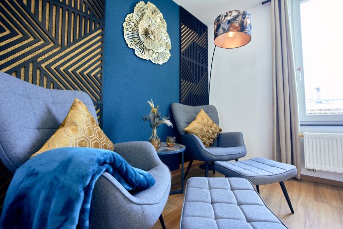 Luxuriöse Sesselecke in blau und gold im hellen Wohnbereich